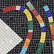 Table topped with a ceramic mosaic featuring an abstract design.