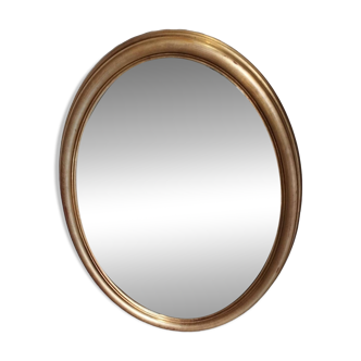 Large and elegant oval gilded mirror with its beveled glass