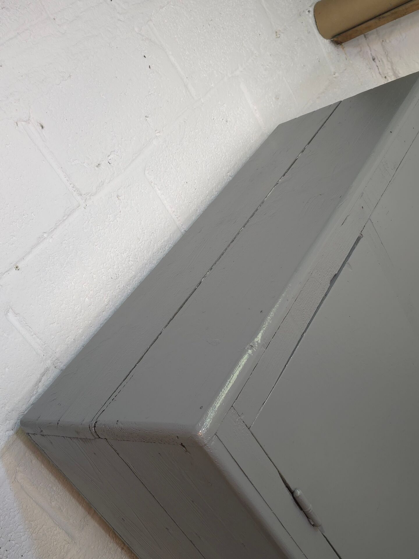 Curved wardrobe workshop locker made of wood repainted in grey.