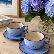 A pair of glazed ceramic cups and saucers from the 60s-70s.