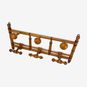 Old coat rack in frame with fixed and mobile hooks