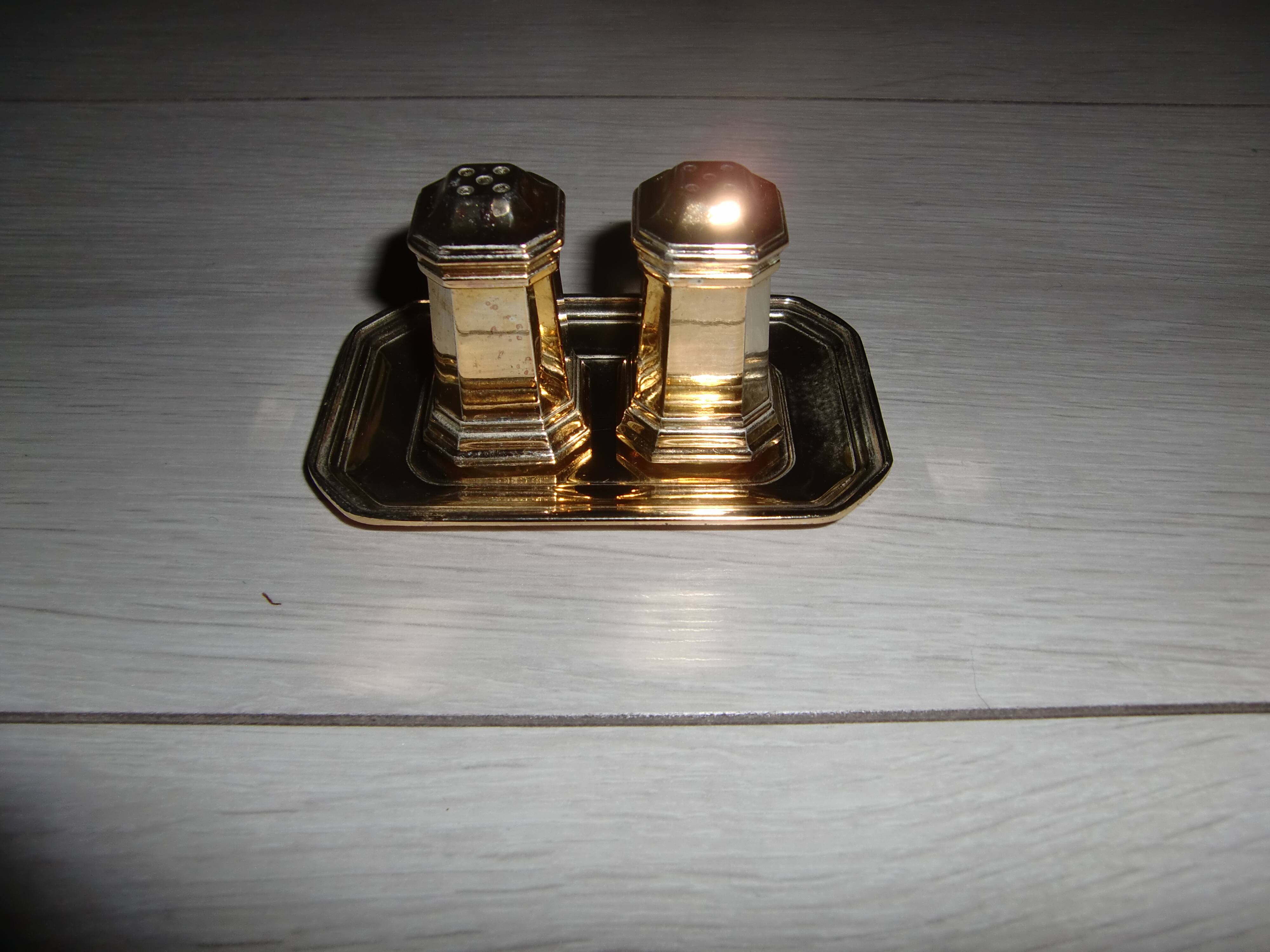 Silver-plated salt and pepper shakers presented on a small tray