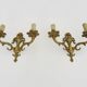 Pair of two-armed fire pot wall lights in gilded bronze.