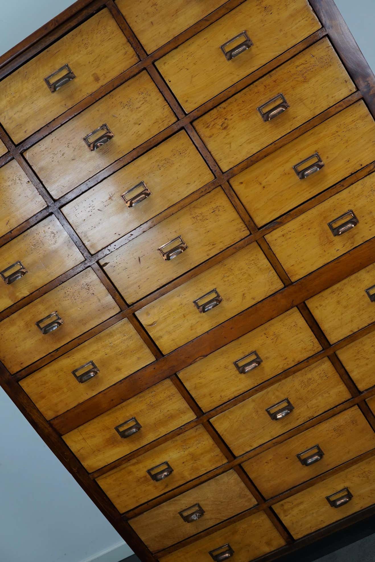 School cabinet bank of vintage Dutch drawers in mid-twentieth century pine