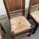 6 dining chairs in a country or farmhouse style, made of dark solid wood and rush-seated.