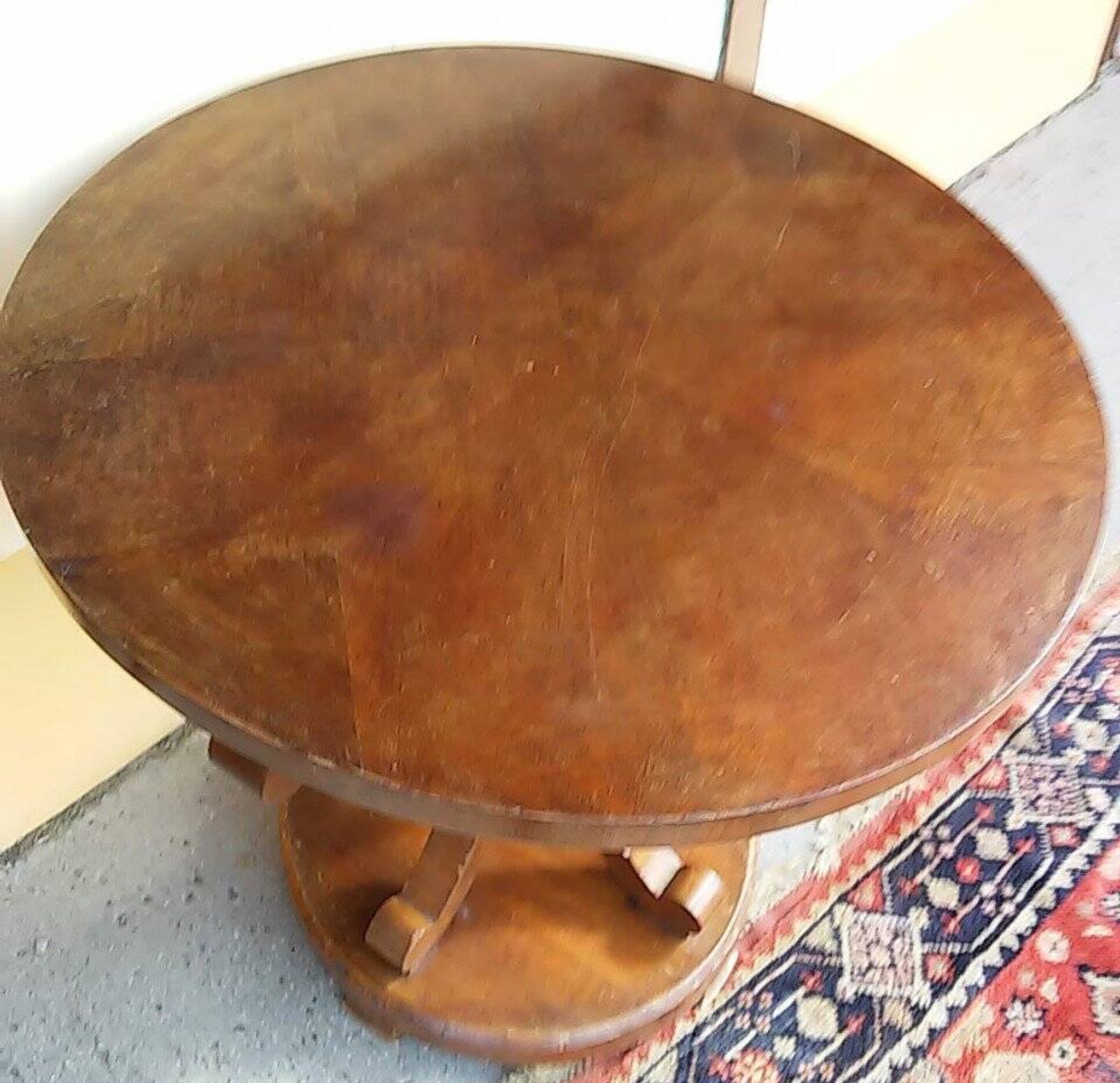 Art Deco side table in brown walnut, round top and scroll legs, France 1930s.