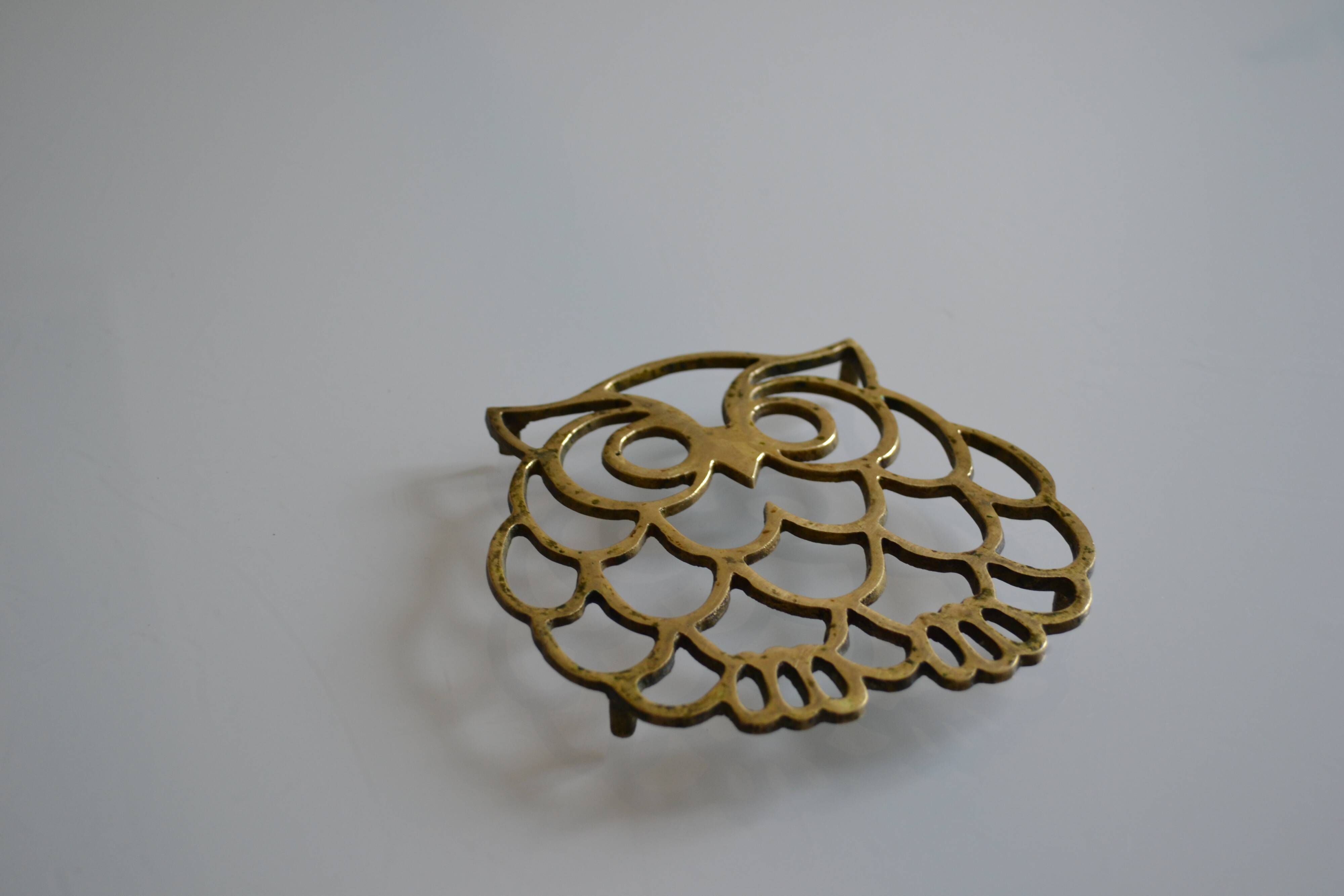 Vintage openwork brass trivet in the shape of an owl or owl