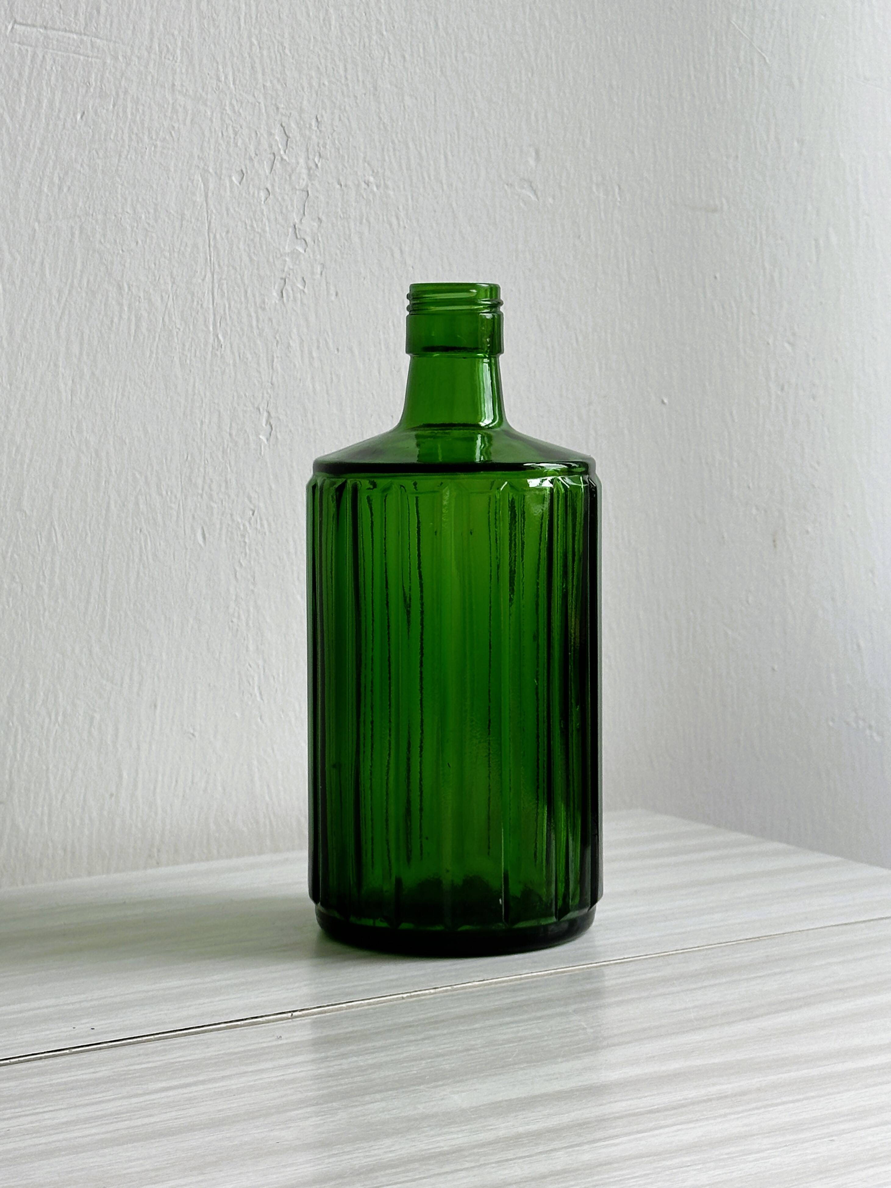 Green glass bottle, ribbed design.