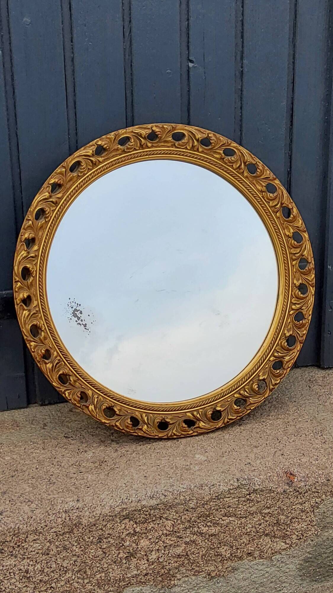Round neoclassical style mirror in wood and gilded stucco from the 1950s