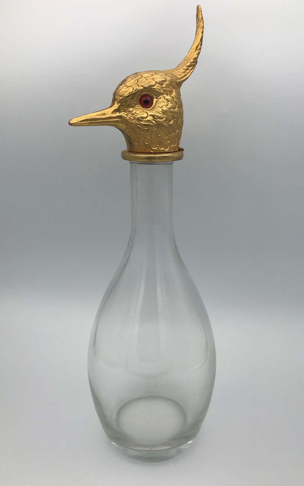 Glass bottle type carafe with gold metal bird head stopper