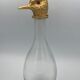 Glass bottle type carafe with gold metal bird head stopper