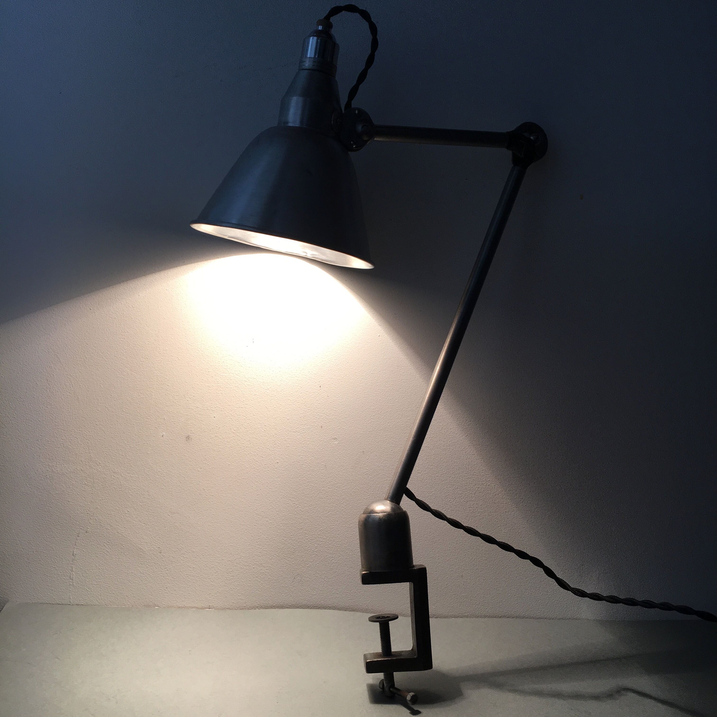 Old industrial lamp has vise 'mazda '.