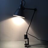 Old industrial lamp has vise 'mazda '.