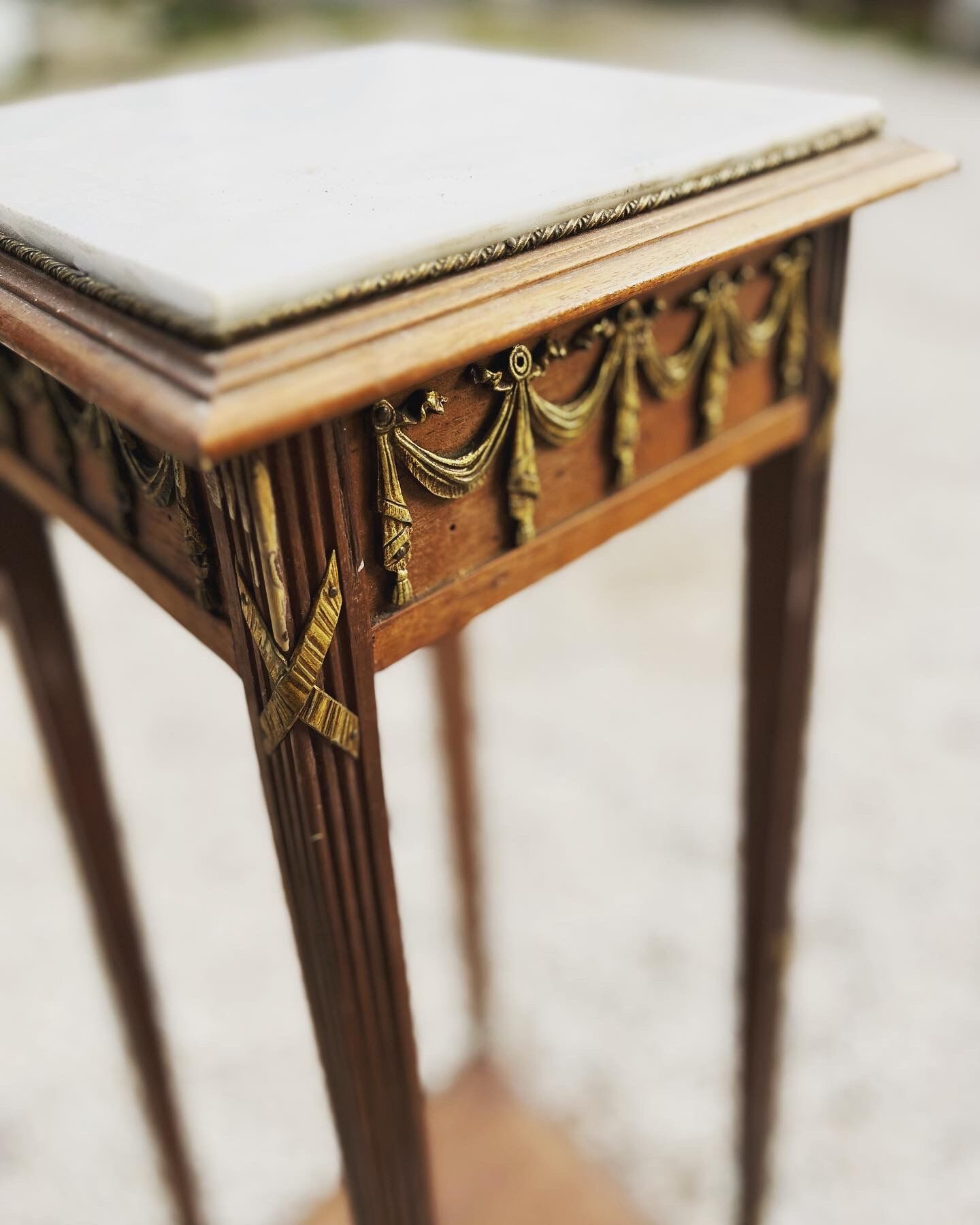 Pedestal table with white marbe top and brass decoration