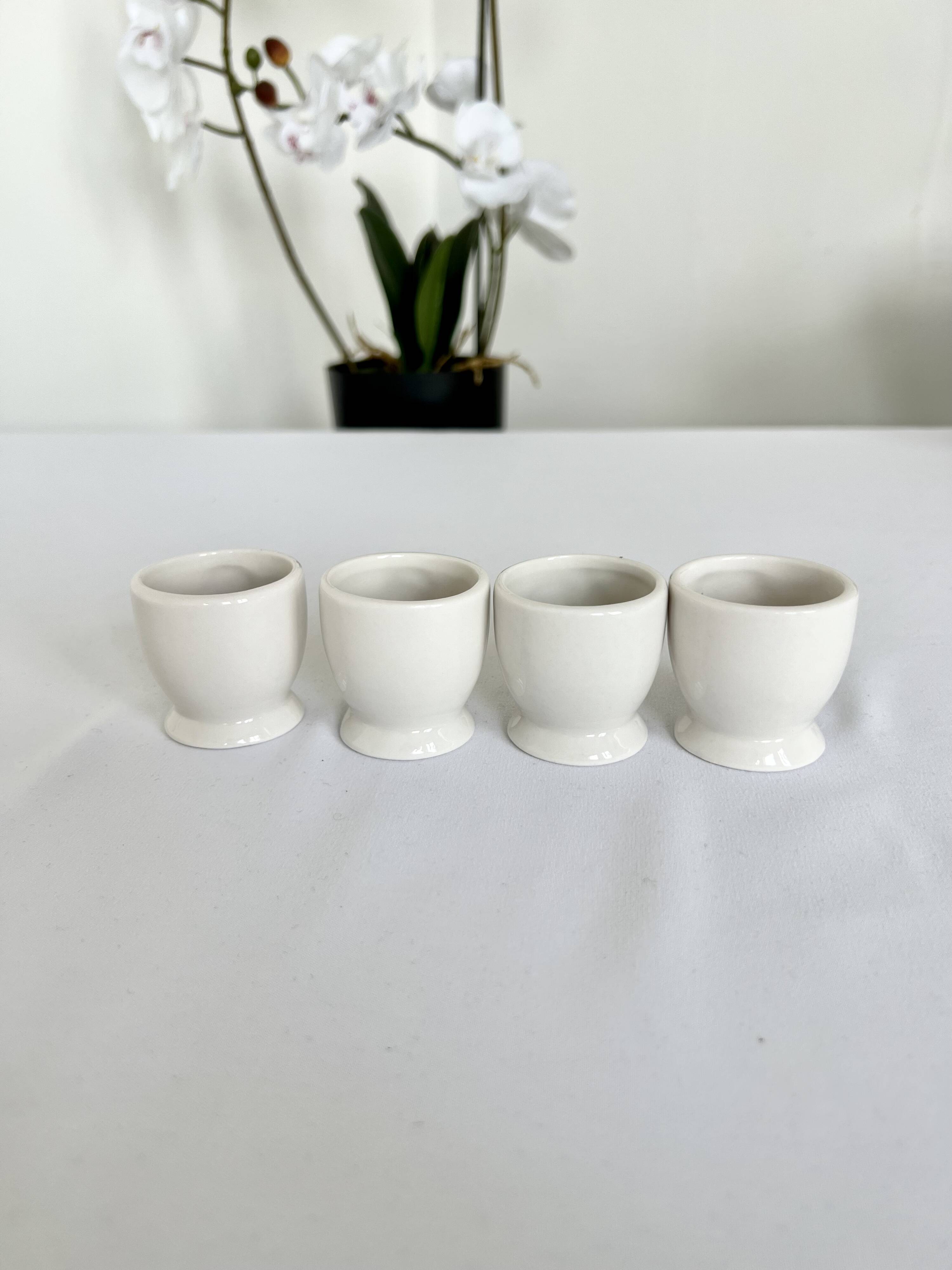 Quatre coquetiers vintage barbotine motifs fleurs et fruits porcelaine blanche