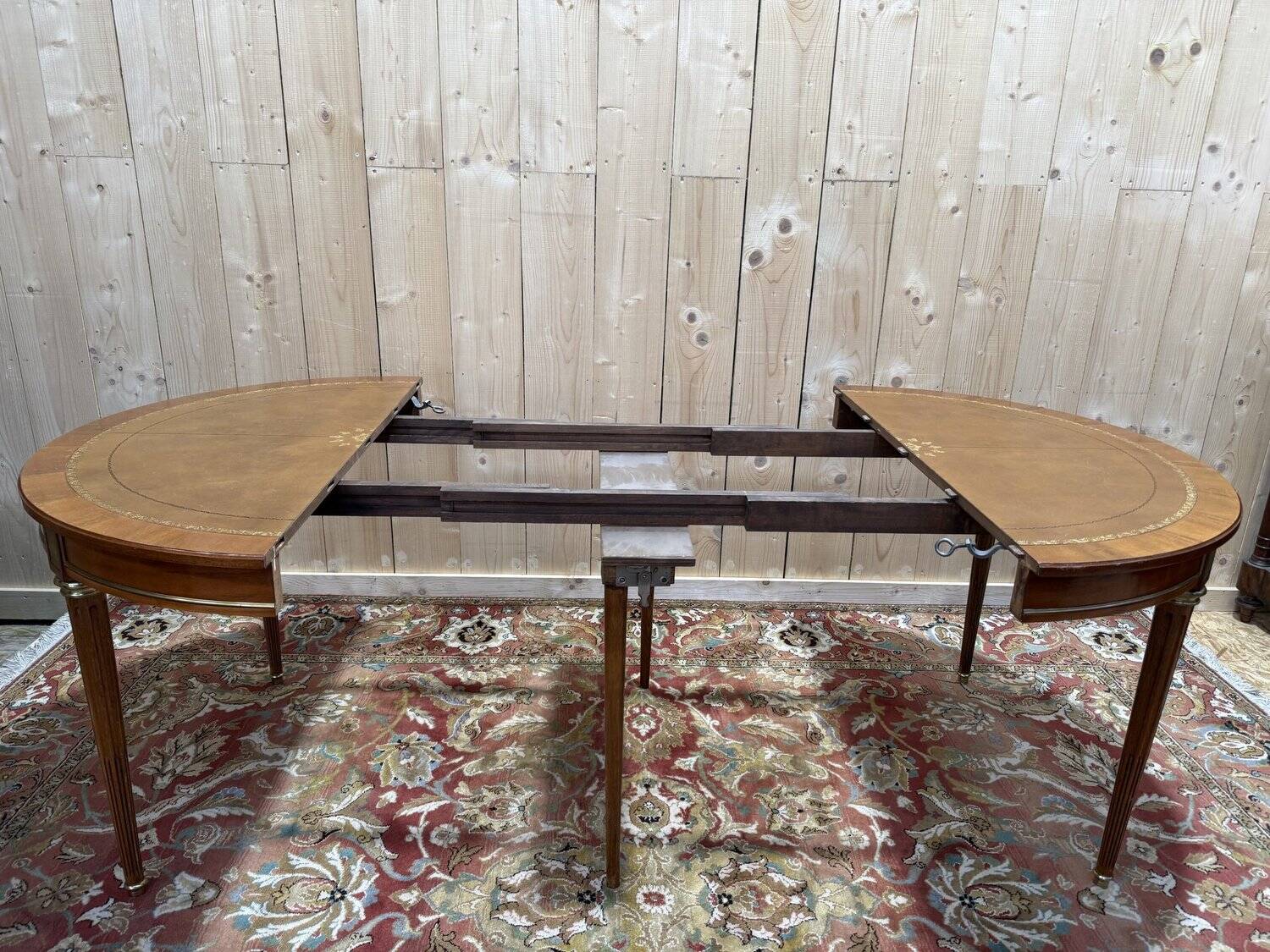 Round dining table with leather top in Louis XVI style.