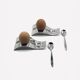 Two egg cups and two stainless steel spoons