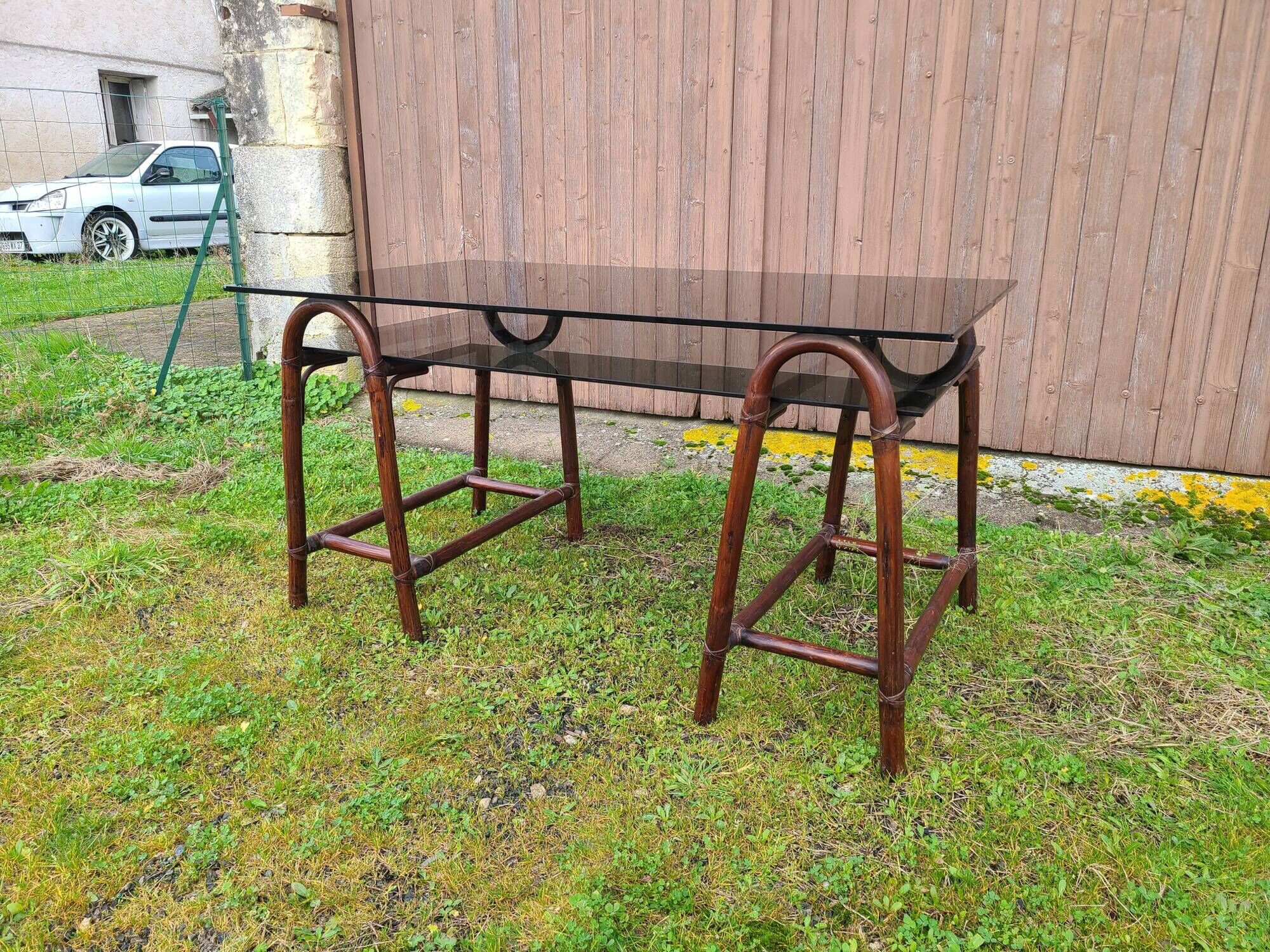 Smoked glass desk on rattan legs and leather detail