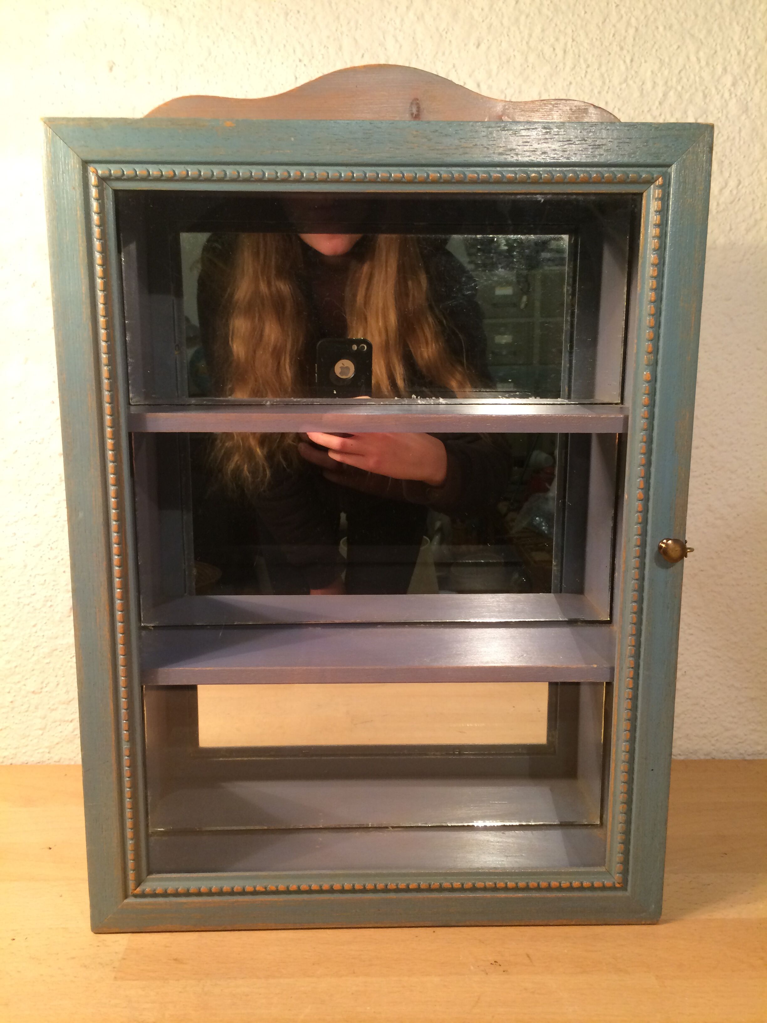 Display shelf with miniature blue wood and mirrors