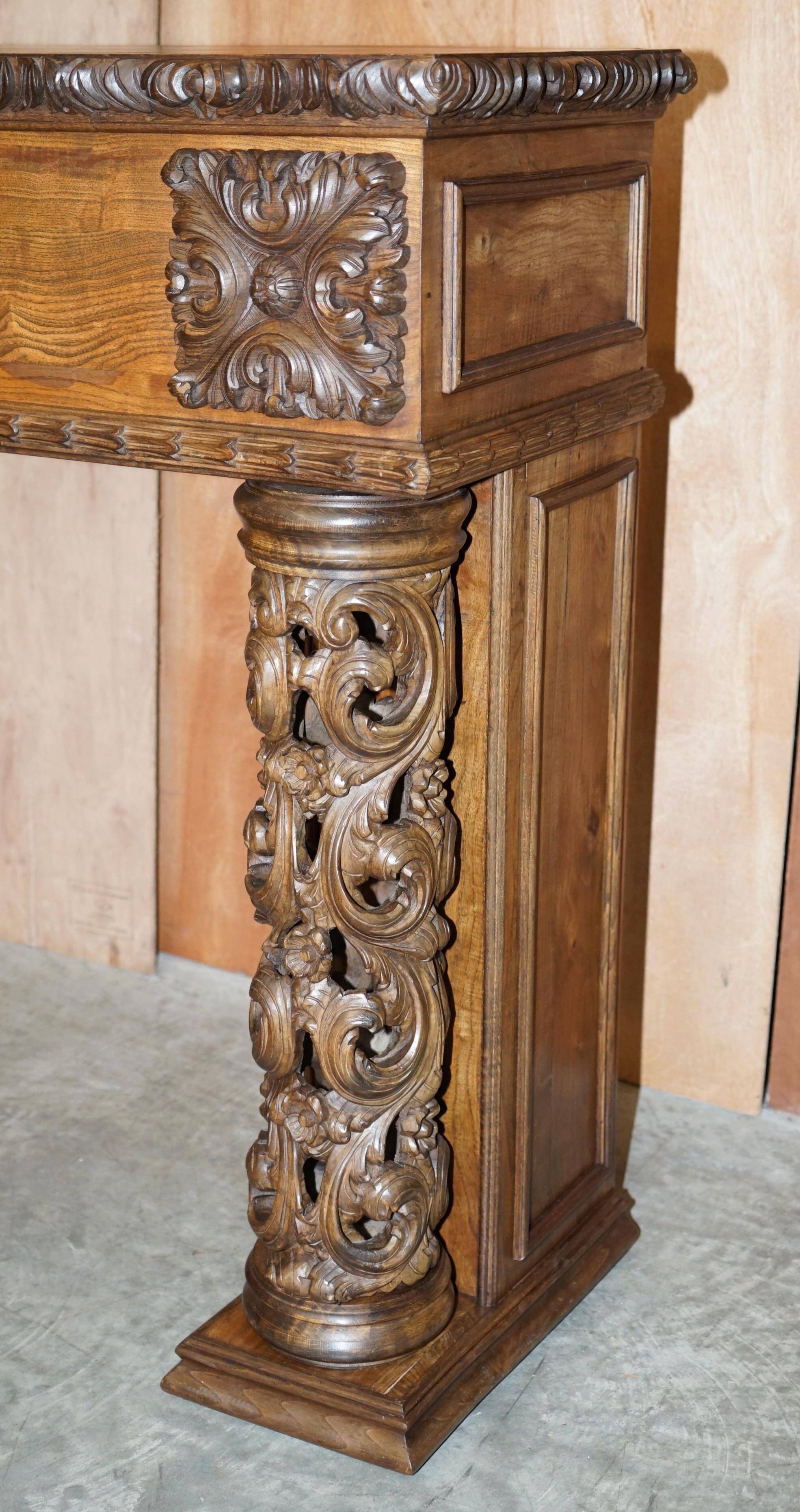 Antique fireplace from around 1880 in solid hand-carved elm with openwork columns.