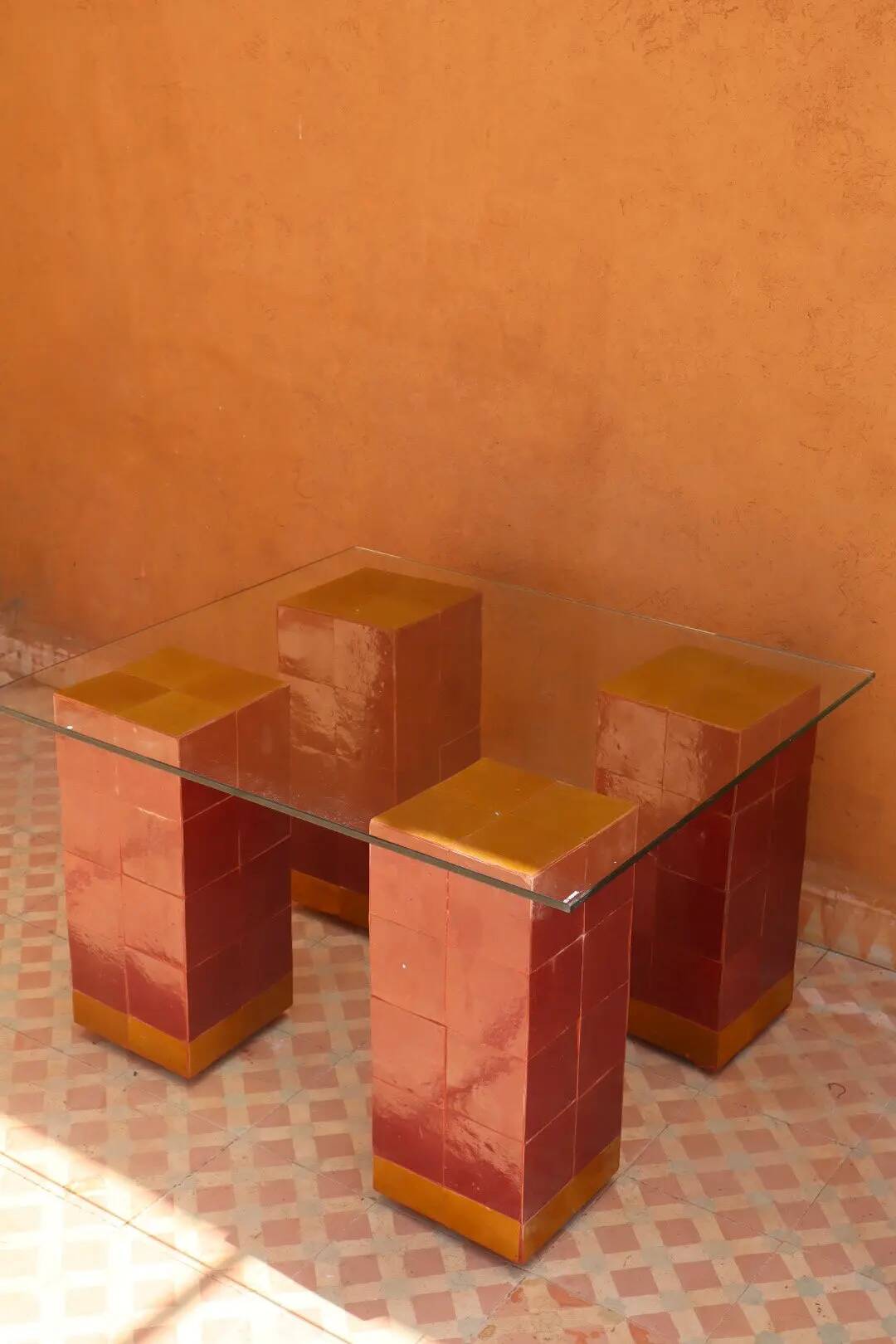 Modern coffee table in burgundy zellige with a tempered glass top.