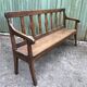 Duo of old solid oak benches with backs and armrests.