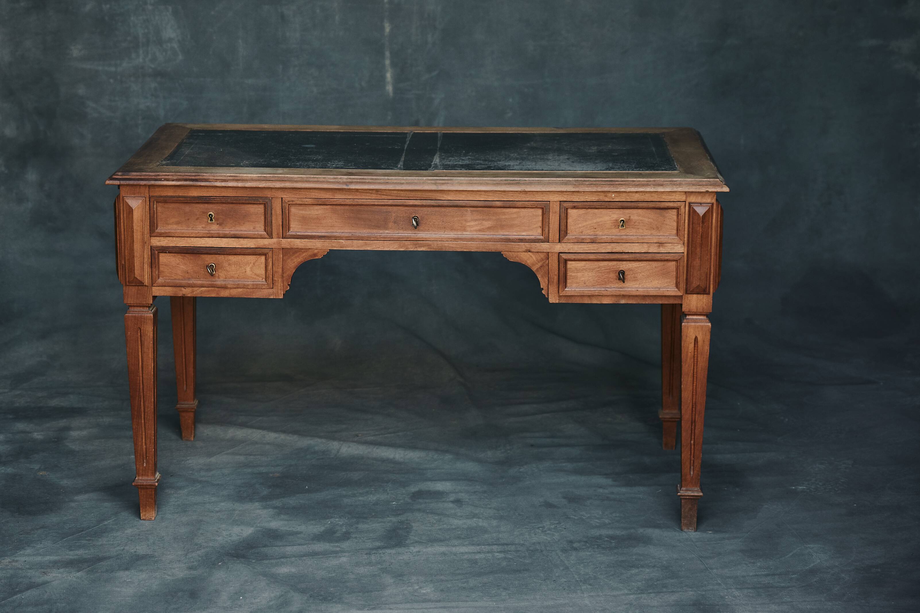 Antique wooden desk with upholstered top and 5 drawers