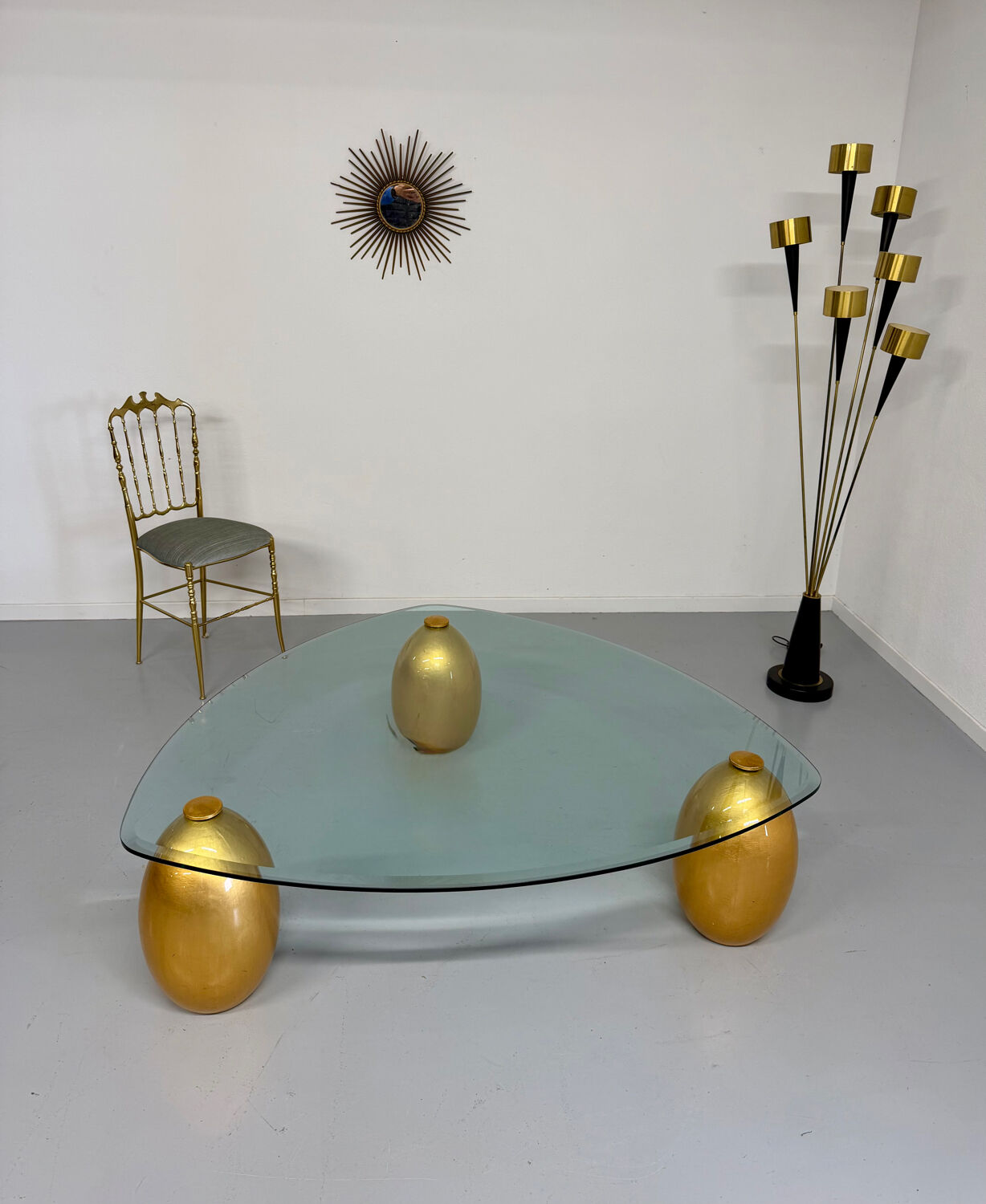 Vintage Italian design coffee table with a glass top and gold base, dating from the 1980s.