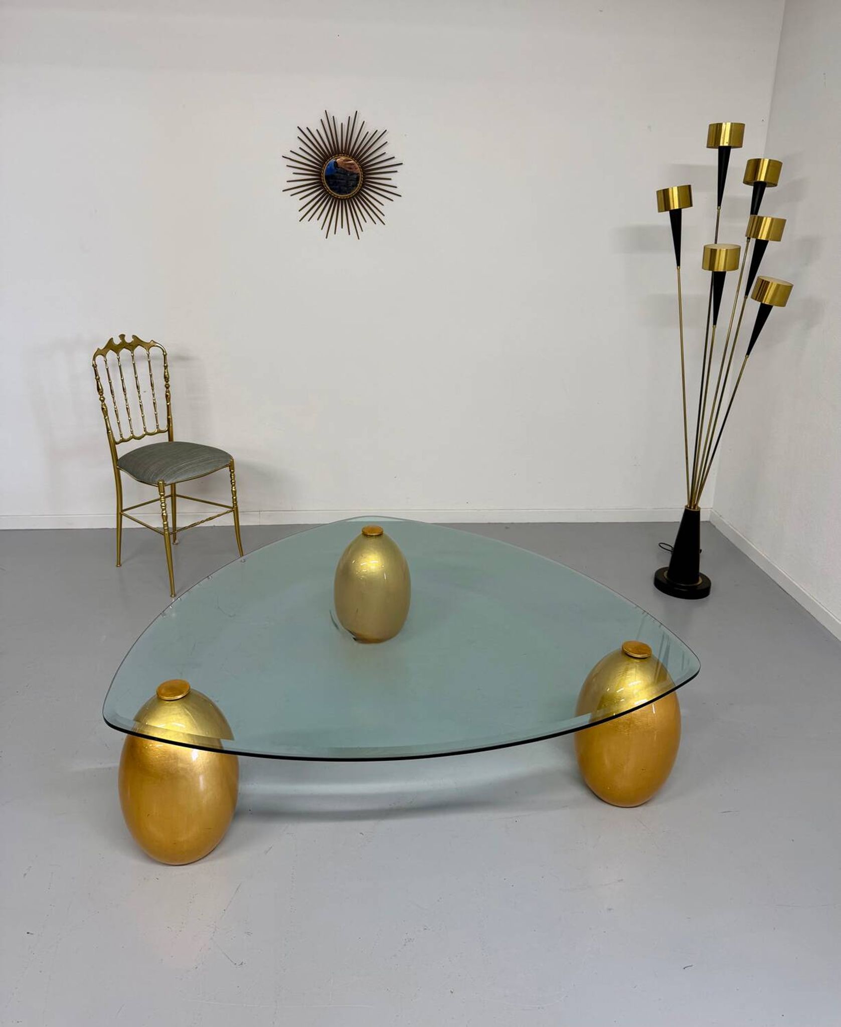 Vintage Italian design coffee table with a glass top and gold base, dating from the 1980s.