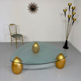 Vintage Italian design coffee table with a glass top and gold base, dating from the 1980s.