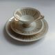 Solitaire tea cup, saucer, and dessert plate in white and gold.
