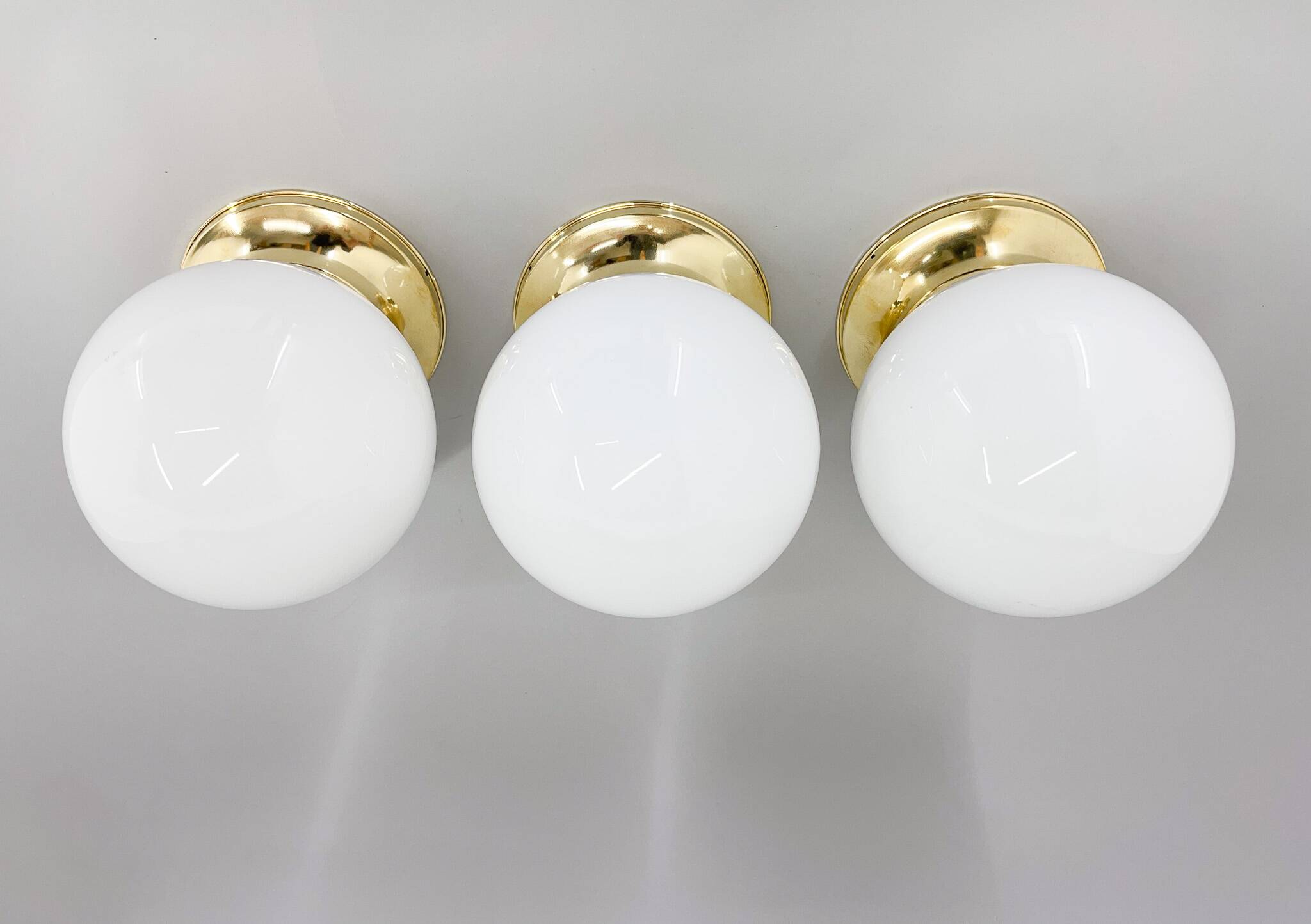 Set of three mid-century brass and milk glass ceiling ligts, restored
