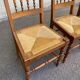 Solid wood chair with a straw seat and carved bar backrest.