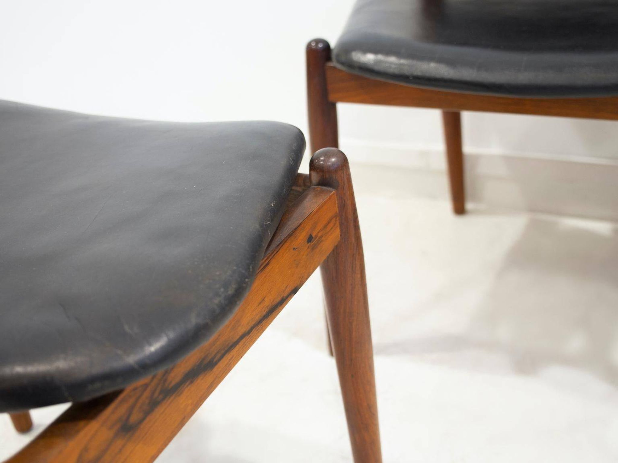 Set of four Arne Vodder chairs in hardwood and black leather.