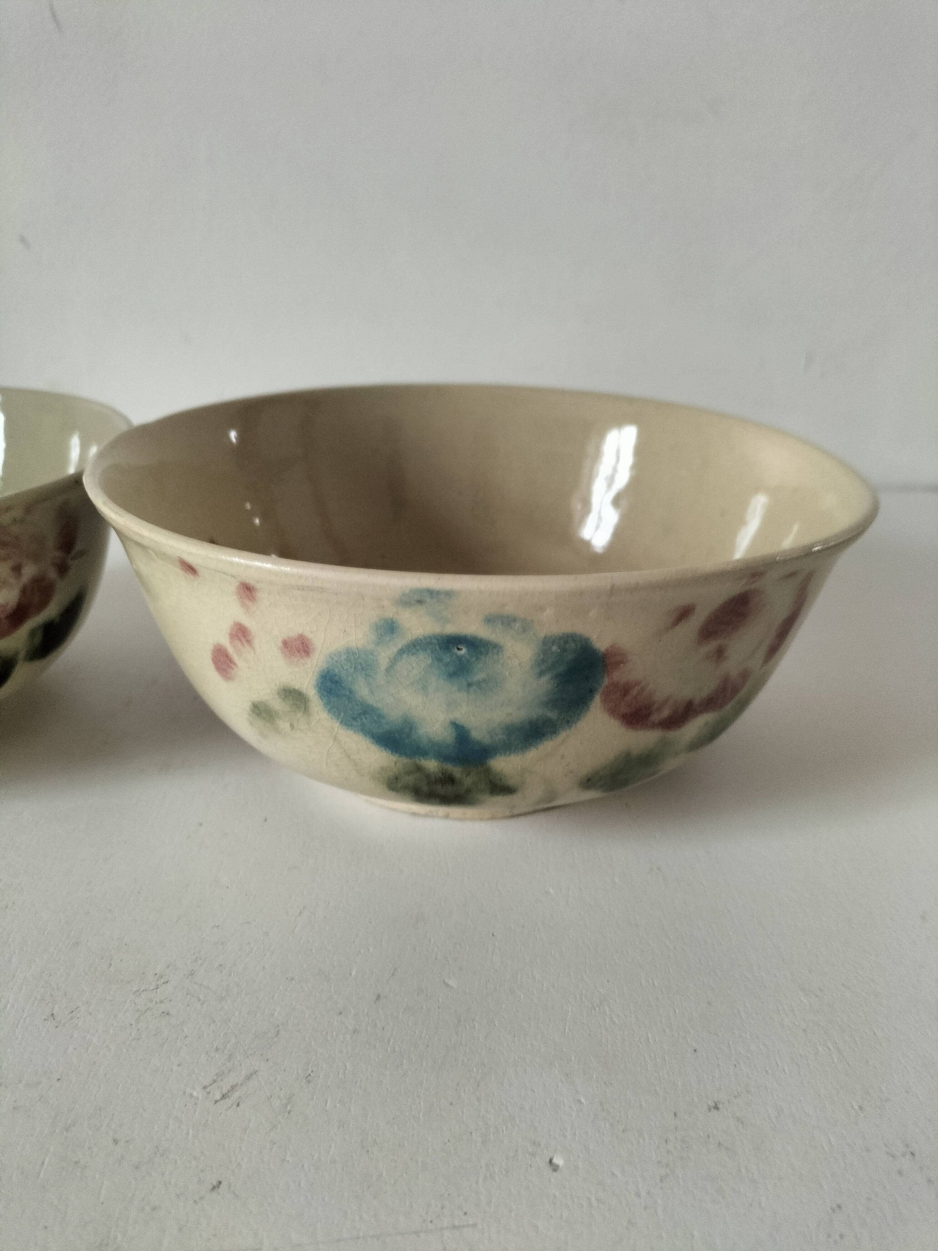Two large vintage bowls in pastel decor on mini pedestals.