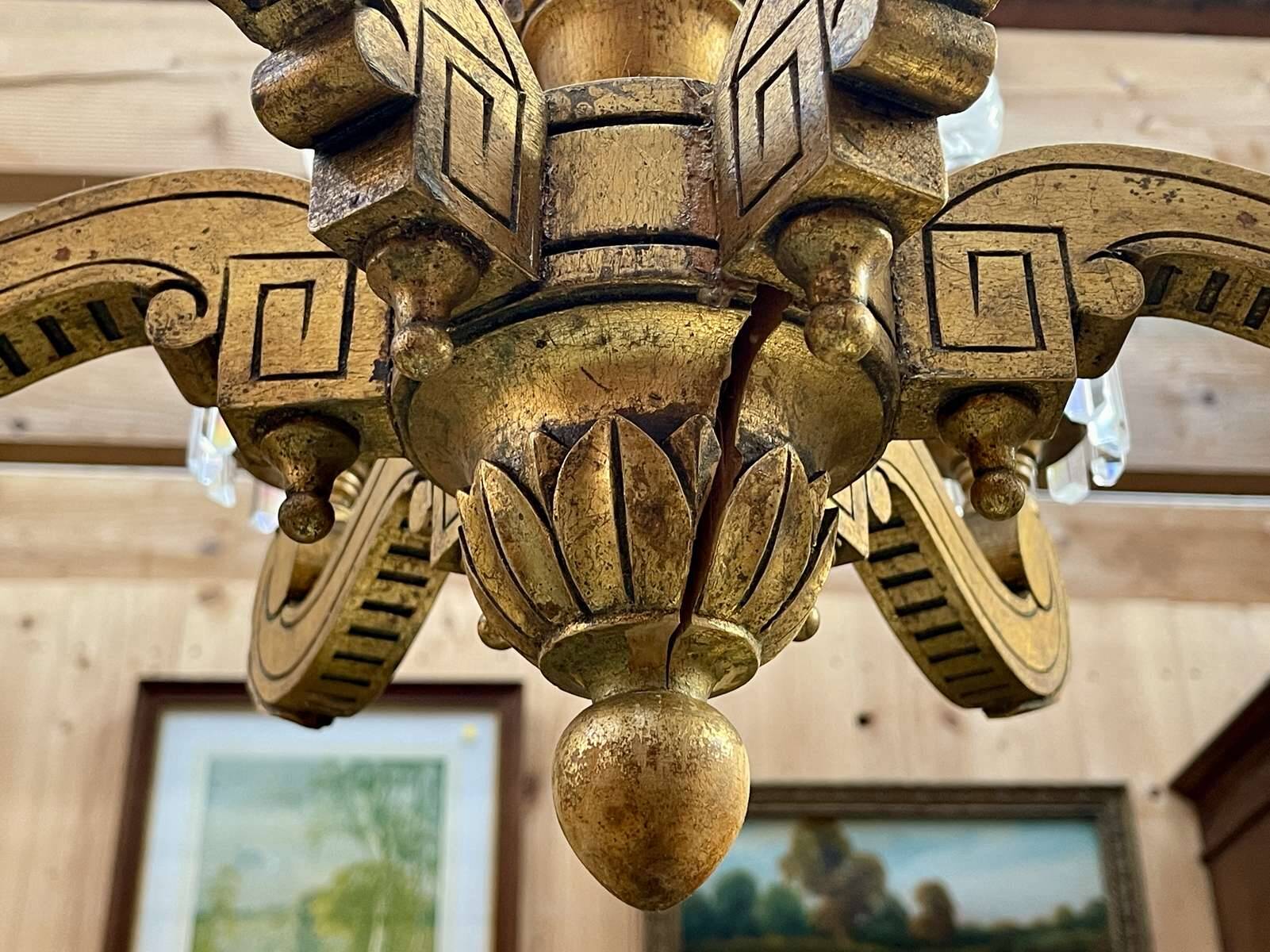 Golden wooden chandelier with crystal pendants from the 19th century.