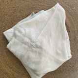 Damask tablecloth with a floral pattern and a central embroidered monogram.