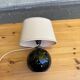 Vintage 80s table lamp with a black ceramic base and beige shade.