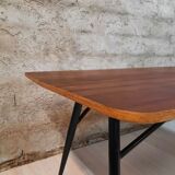 Table à manger en bois de teck et pieds en métal peint.
