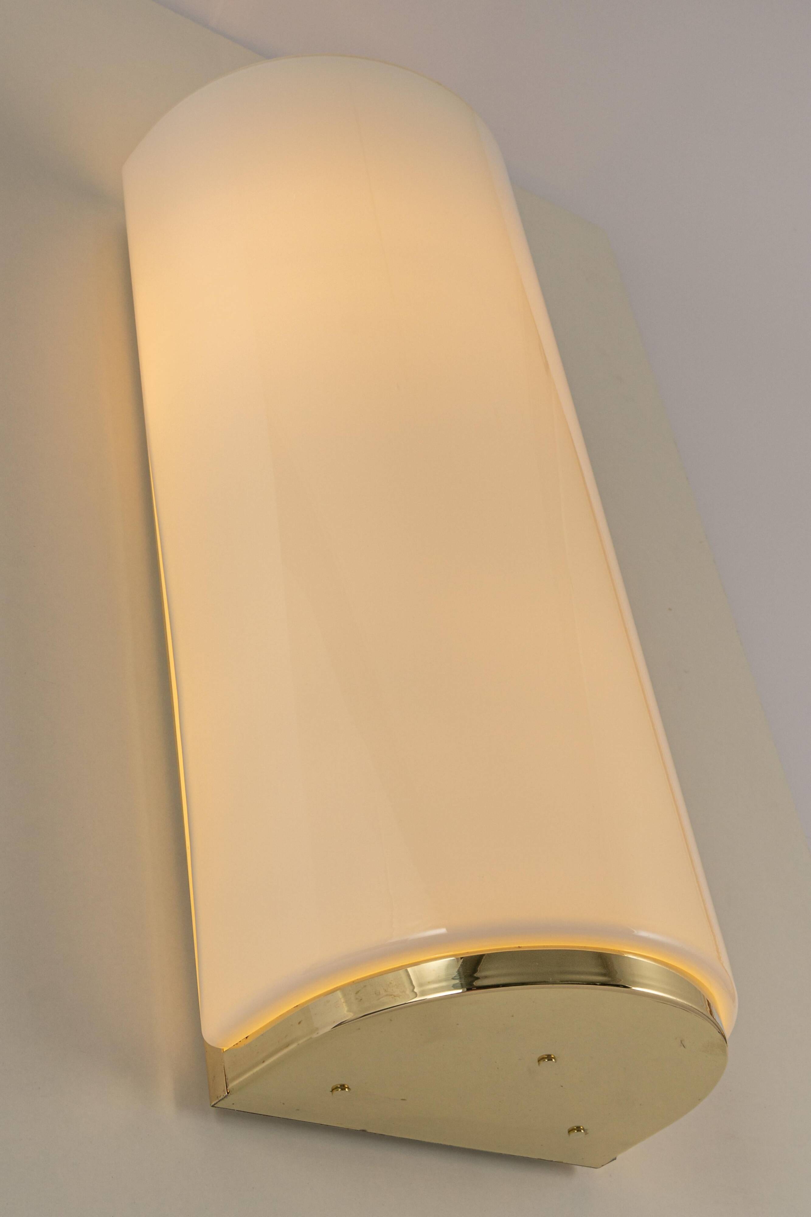 Pair of large opaline glass wall lights in brass designed by Limburg, Germany.