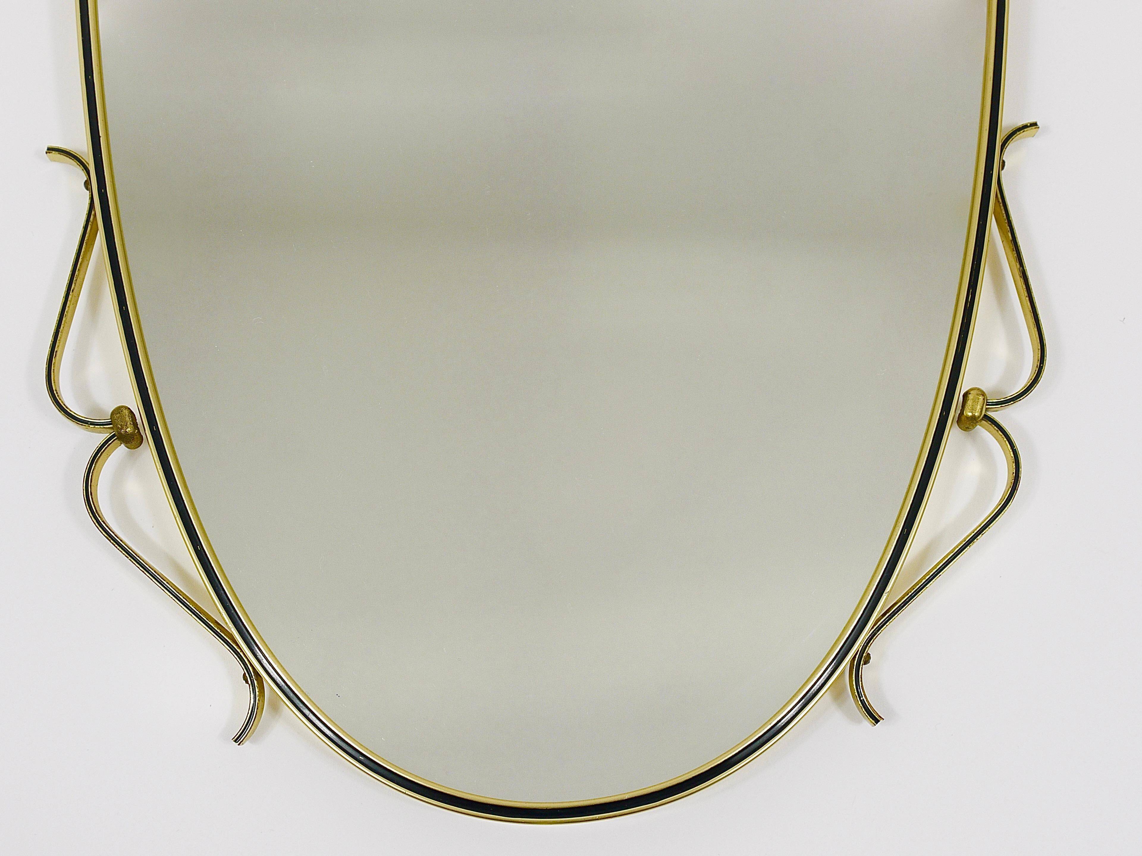 Elegant wall mirror in brass and black from the mid-century, Italy, 1950s.