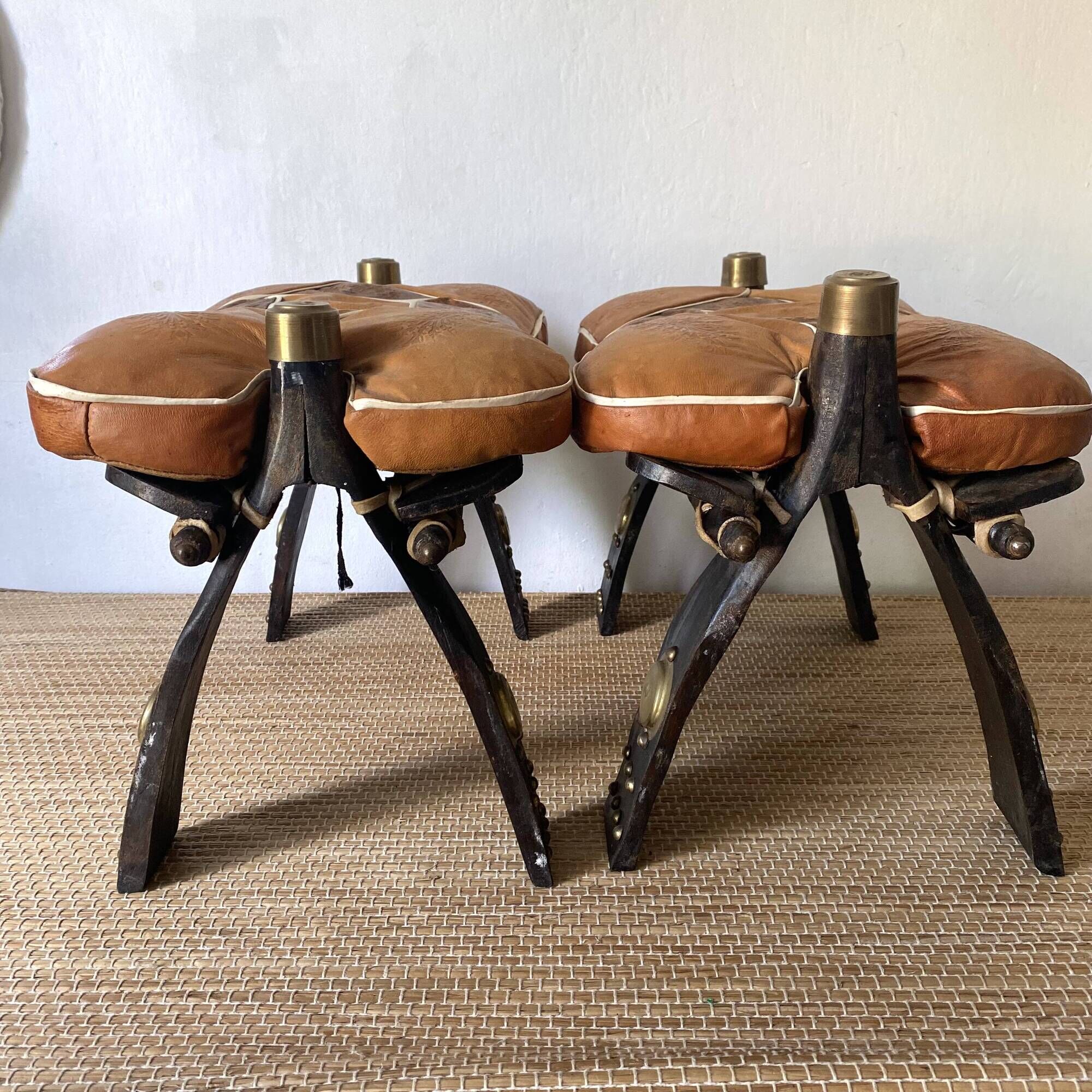 Pair of low Egyptian stools, camel saddles in wood, leather and brass