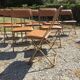 Set de 12 chaises vintage pliantes en skaï assises et dossiers matelassés à piètement tubulaire doré