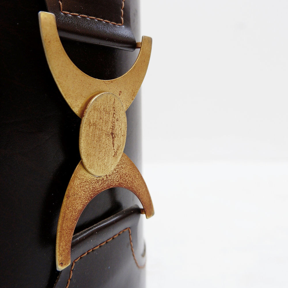 Brown leather wastepaper basket with decorative gold metal buckle.
