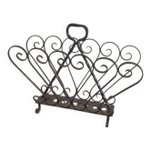 Vintage 1950s black wrought iron magazine rack with scroll decorations.