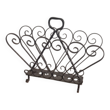 Vintage 1950s black wrought iron magazine rack with scroll decorations.