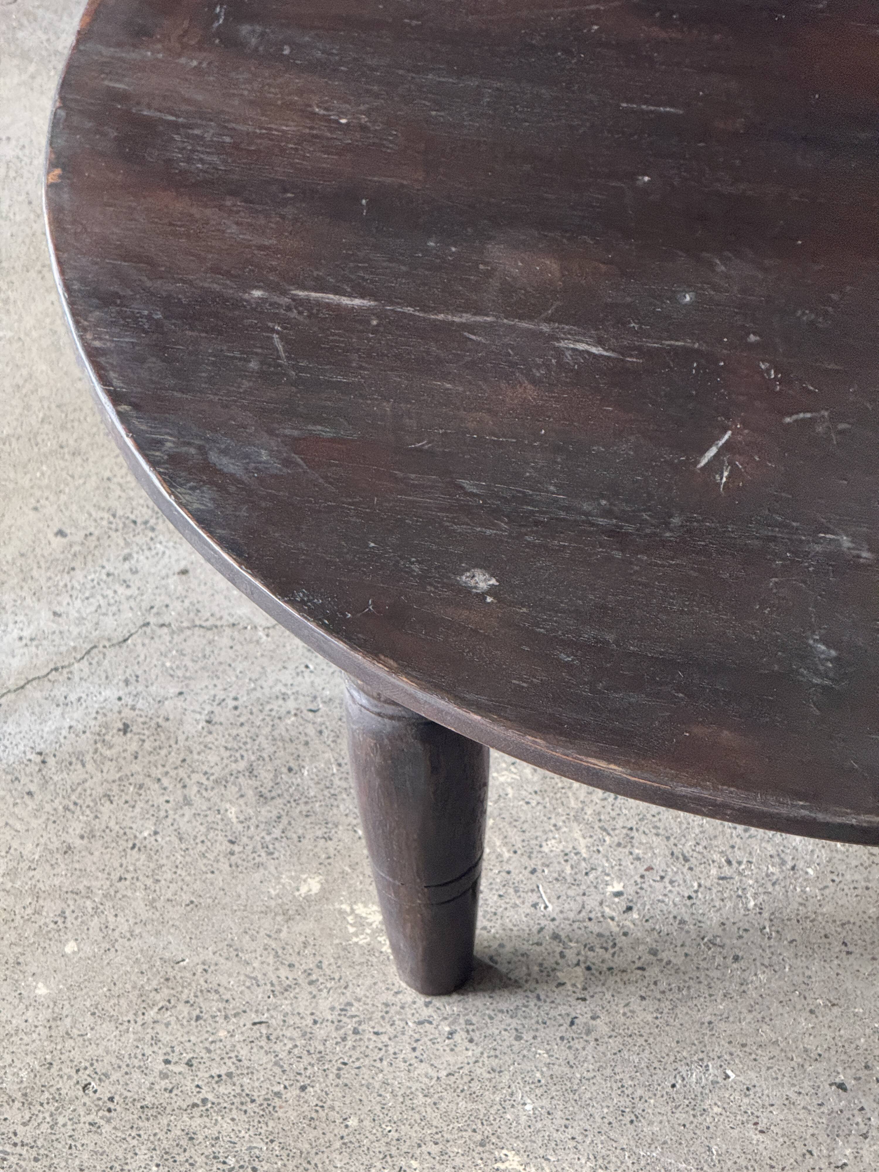 Antique round coffee table in Indonesian teak with turned legs.