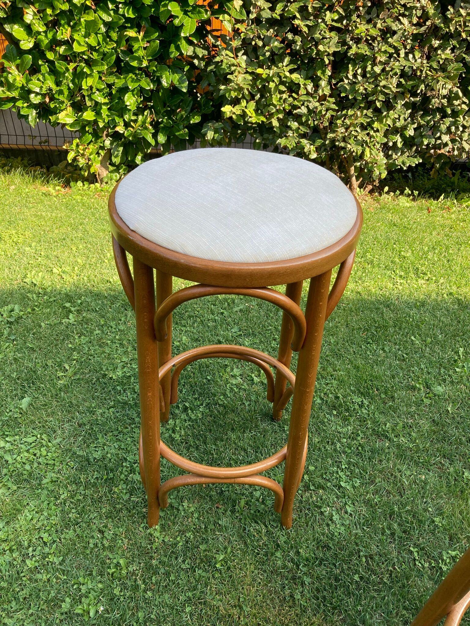 3 bar stools made of curved wood and fabric seat