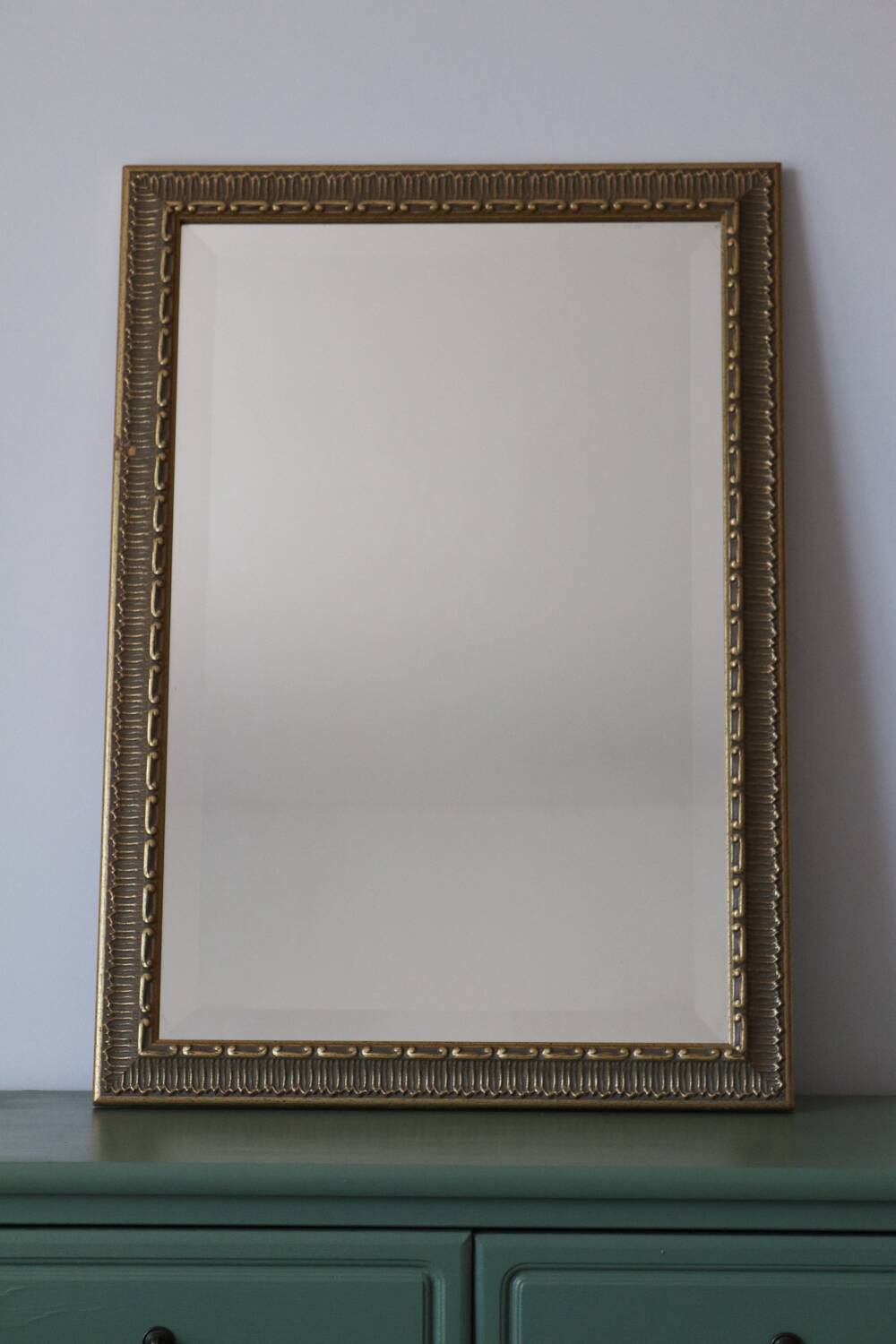 Rectangular gold mirror with moulded decoration.