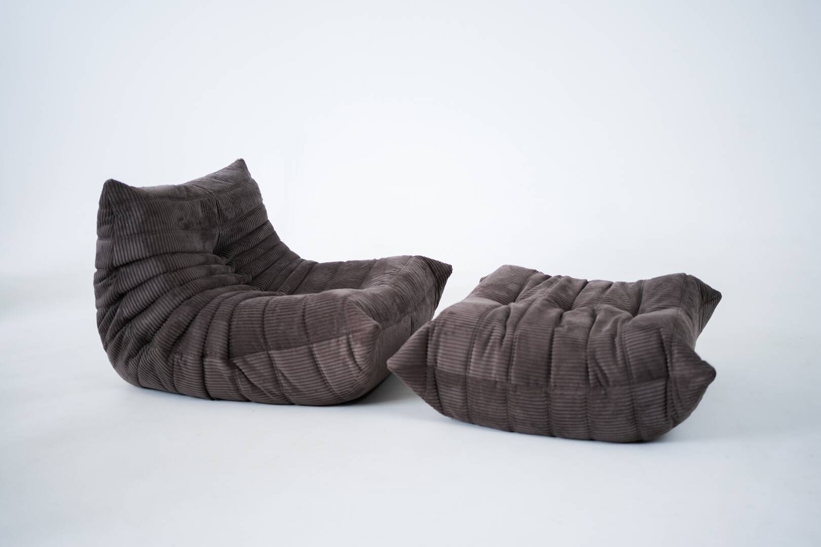 Ensemble de chaise et pouf Togo en velours côtelé marron.